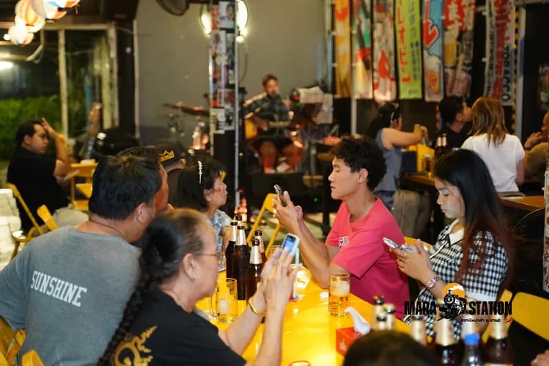 โต๊ะเพื่อนกับเบียร์เย็นขณะวงดนตรีสดเล่นอยู่ด้านหลังที่ Mara Station