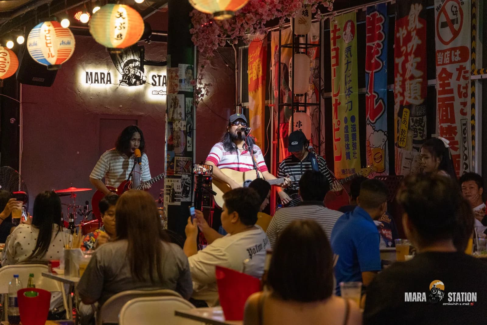 ผู้ชมยืนชมวงดนตรีสดเต็มร้านที่ Mara Station