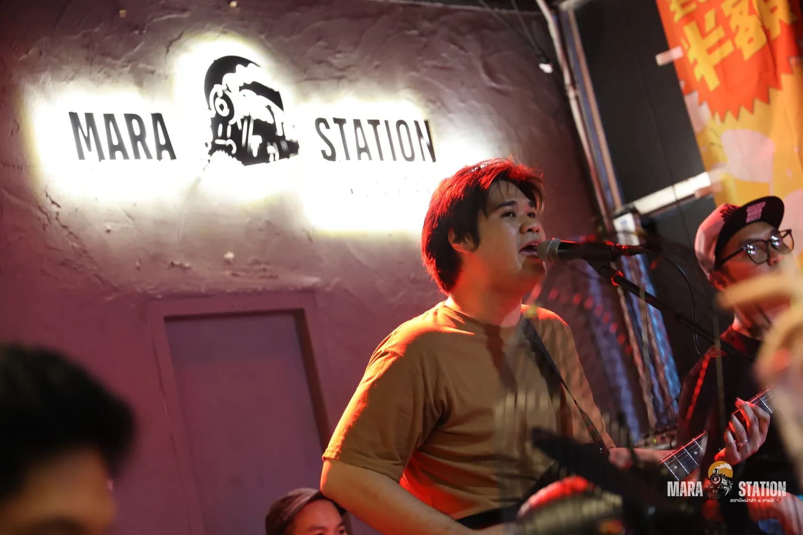 นักร้องวงสดร้องเพลงใต้ป้ายไฟ Mara Station